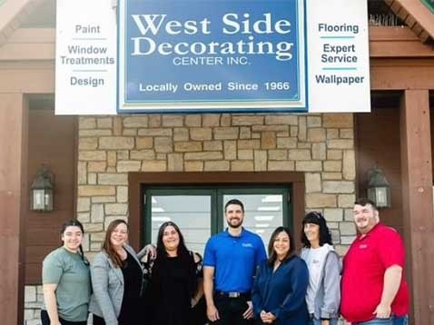 Company staff posing for a photo together by the storefront
