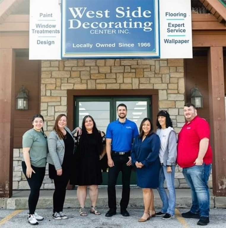 Company staff posing for a photo together by the storefront